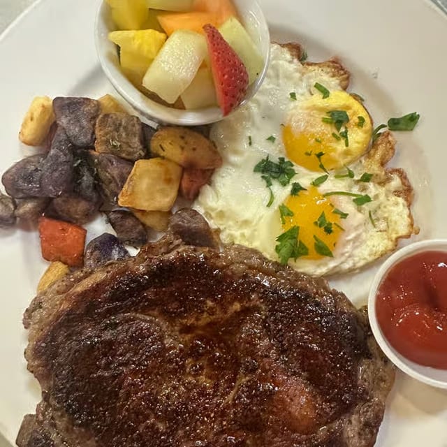 Grilled angus certified rib eye steak and eggs brunch.