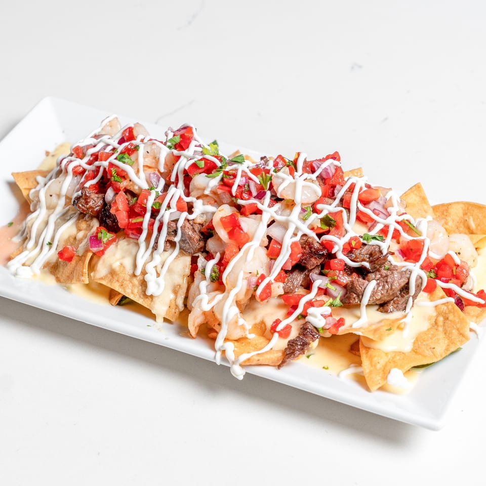 Pear Street Bistro's loaded nachos with steak, shrimp, pico de gallo, and a drizzle of white sauce.